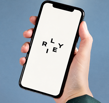 A hand holding a RILEY phone against a blue background.